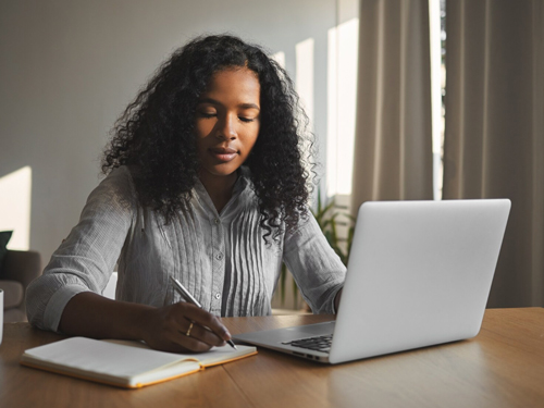 professional female takes notes while watching Module 2 lessons