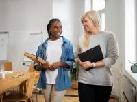 professional female walks and talks to younger female in office